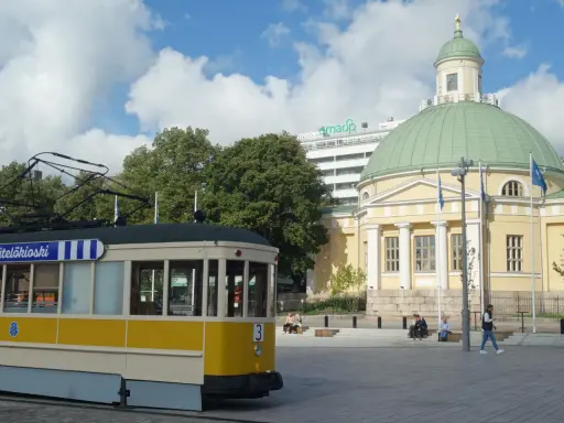 Żółty tramwaj na tle katedry i nowoczesnego budynku. Turku atrakcje to nie tylko zabytki, ale i miejska komunikacja.