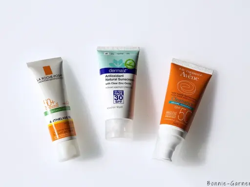 Trois tubes de crème solaire (La Roche-Posay, Dermale, Avène) pour montrer à quoi sert la crème solaire : protéger la peau des rayons UV.