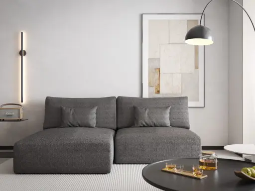 Nowoczesny salon z szarą kanapą, na ścianie pionowa lampa emitująca zielone światło. Czy zielony pasuje do szarego? Tak, tworzy przytulną atmosferę.