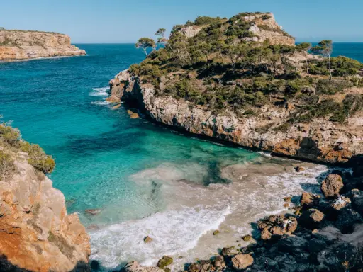Malownicze wybrzeże z turkusową wodą i skalistymi klifami, idealne miejsce na wakacje na Palma de Mallorca.