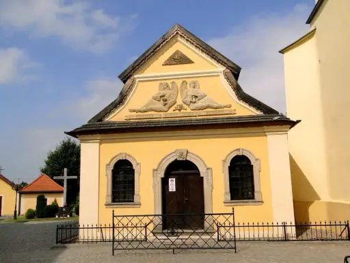 Żółta kaplica czaszek w Czermnej z aniołami i napisem "Kaplica Czaszek".
