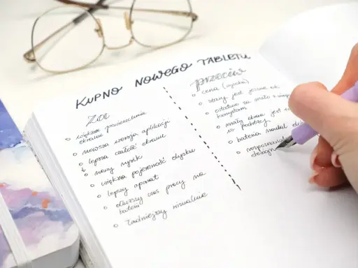 Estetyczne notatki: lista "za" i "przeciw" przy zakupie nowego tabletu. Długopis pisze na kartce w kropki.