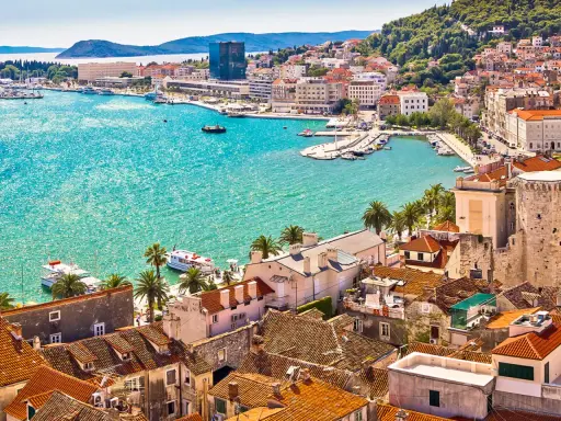 Vacker kuststad i Kroatien med turkost vatten och båtar. En drömresa, kanske med vaccin Kroatien i åtanke för en trygg semester.