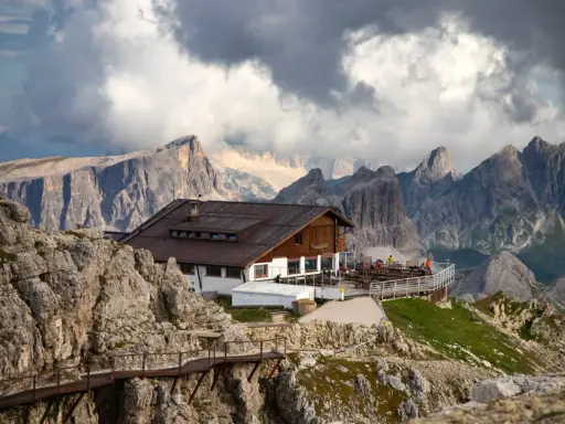 Rifugio alpino in Alto Adige, con sentiero metallico e imponenti vette sullo sfondo.