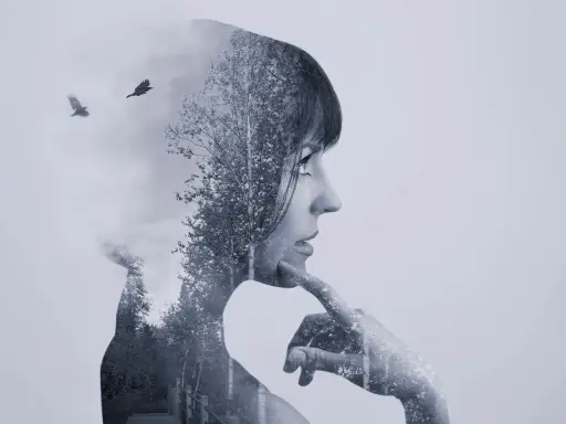 Silueta de mujer pensativa en **doble exposición**, con un bosque y dos cuervos volando.