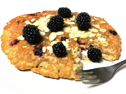 Omlet z jabłkiem i jeżynami, posypany płatkami migdałów. Pyszne śniadanie czeka na widelca.