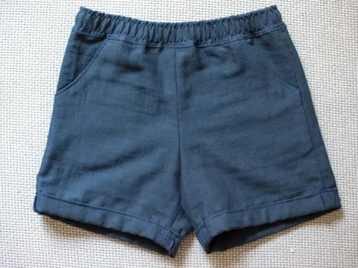 Mörkblå sy shorts med resår i midjan och fickor. Perfekta för lek och äventyr.