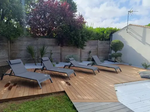 Aménagement terrasse en bois avec chaises longues invitant à la détente. Un espace extérieur parfait pour profiter du soleil.