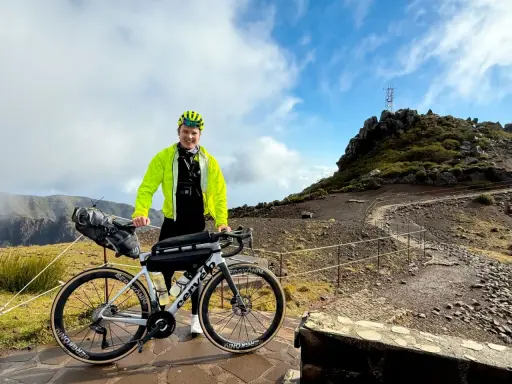 Glücklicher Radfahrer mit seinem Rennrad auf Madeira, bereit für eine Bergfahrt.