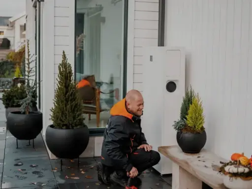 Tekniker arbetar med en värmepump, en del av ett eco kraft-system för ett modernt hem.