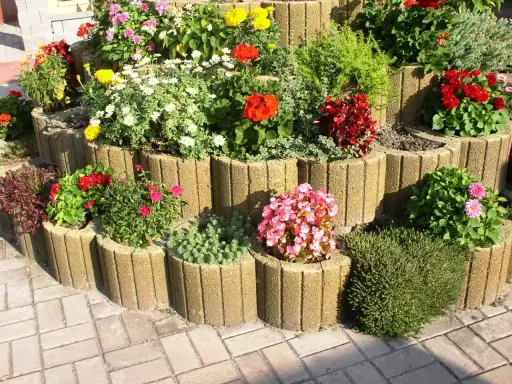 Kwiaty w donicach z betonu: czerwone, różowe, białe i żółte. Inspiracja, co posadzić w gazonach, by stworzyć barwny ogród.