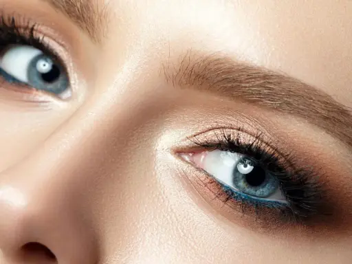 Nahaufnahme eines blauen Auges mit braunem Lidschatten und blauer Eyeliner-Linie. Perfekt für die Frage: welche haarfarbe bei blauen augen.