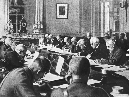 Männer in einem prunkvollen Raum diskutieren den Inhalt des Versailler Vertrags.