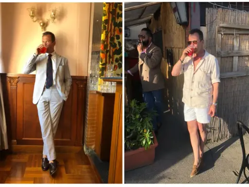 A man in a light-colored Havana suit sips a drink. Another man smokes a cigar.