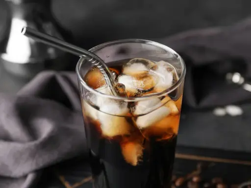 Erfrischender Cold Brew Kaffee in einem Glas mit Eiswürfeln und einem Metallstrohhalm. Perfekt für heiße Tage.