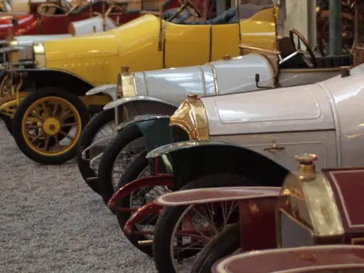 Reihe von Oldtimern, von denen jeder einen hohen schlumpf autosammlung wert hat. Gelb, weiß und rot sind die dominanten Farben.