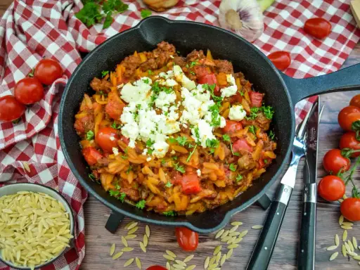 Herzhaftes Kritharaki-Gericht mit Hackfleisch, Tomaten und Feta in einer Gusseisenpfanne. Perfekt für leckere Kritharaki Rezepte.