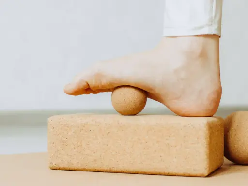 Fuß mit Ball auf Korkblock für Plantarfasziitis Dehnen.