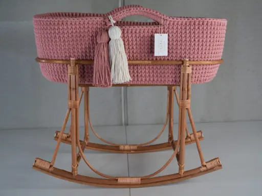 Moisés crochet rosa con borlas y base de mimbre. Un lugar acogedor para el bebé.