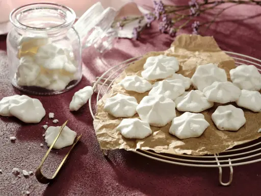 Luftige Baiser-Häppchen, perfekt für vegane aquafaba rezepte. Ein Glas voller süßer Leckereien und ein paar auf einem Gitter.