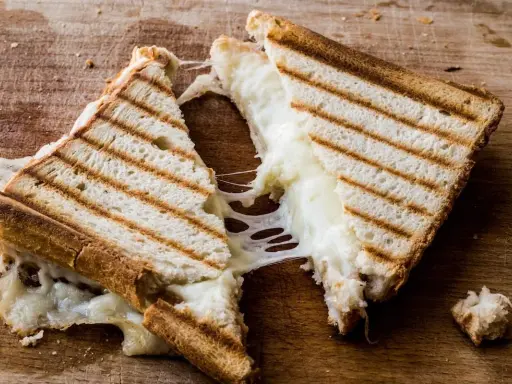 Pyszny, ciągnący się ser w tostach. Zastanawiasz się, ile kcal ma tost z serem? Ten wygląda na około 300-400 kcal.