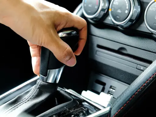 Mano operando la palanca de **cambio automático como funciona** en un coche moderno.