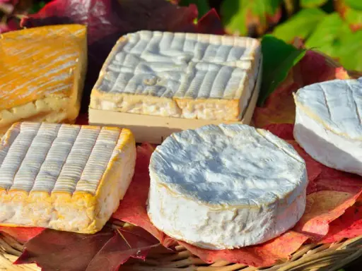 Assortiment de fromages, dont un en forme de cœur, évoquant les spécialités culinaires de Rouen.