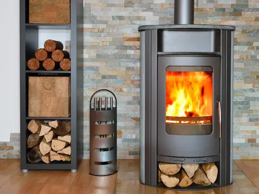 Un poêle à bois ou à granulés crépite joyeusement, réchauffant la pièce. Des bûches sont rangées à côté, prêtes à alimenter le feu.