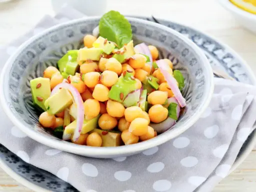 Deliciosa ensalada de garbanzos y aguacate, con cebolla morada y semillas de lino. Fresca y nutritiva.