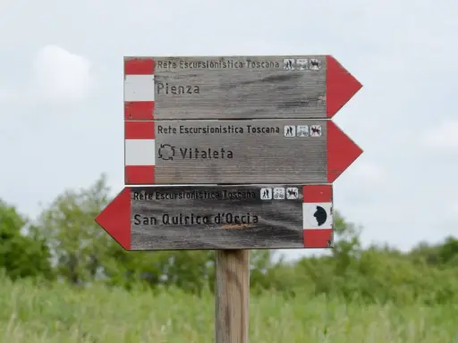 Cartello segnaletico per il trekking in Val d'Orcia: Pienza, Vitaleta e San Quirico d'Orcia.