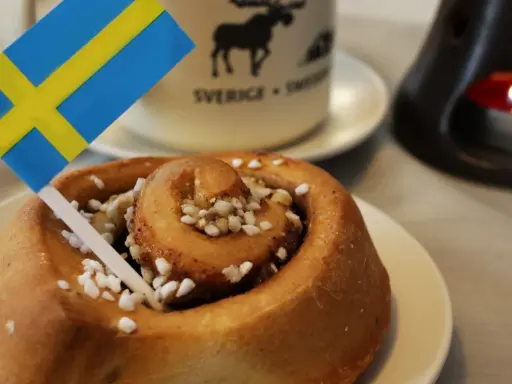 Słodka bułeczka cynamonowa z posypką i flagą Szwecji. To właśnie z takich wypieków słynie Szwecja, idealna na fika.