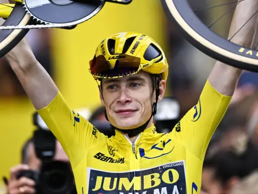 Jonas Vingegaard im Gelben Trikot, mit seinem Rad über dem Kopf. Sein Gehalt ist wohl hoch, bei diesem Erfolg!