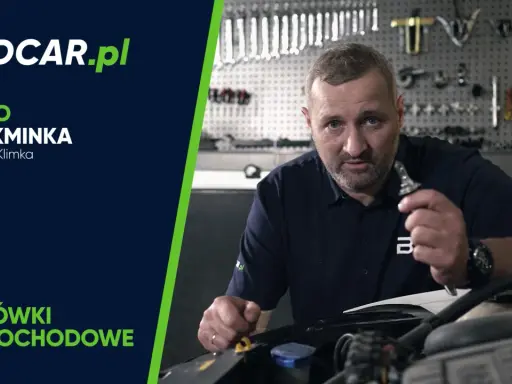 Mężczyzna trzymający żarówkę samochodową w warsztacie.