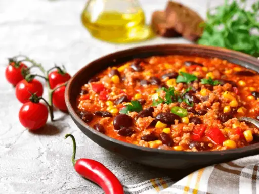 Miska sycącej zupy meksykańskiej z fasolą, kukurydzą i mielonym mięsem. Idealne jakie przyprawy do zupy meksykańskiej? Chili, kumin, papryka.