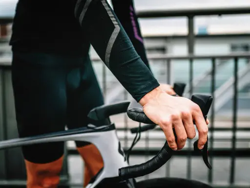 Rowerzysta z silnym bólem ud po jeździe na rowerze, trzymający kierownicę.
