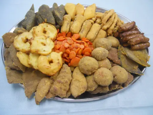 Vassoio con vari piatti tipici torinesi: frittelle, verdure, polpette e salumi.