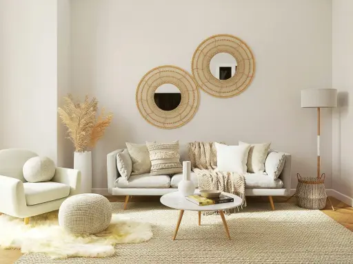 Un salon boheme nature avec un fauteuil douillet, un canapé confortable, des coussins texturés, des miroirs en rotin et des herbes séchées.