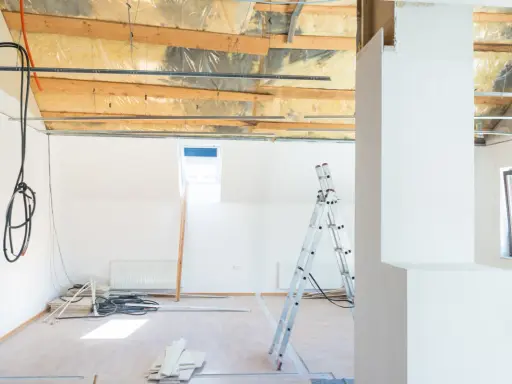 Chantier en cours : câbles électriques apparents, échelle, et matériaux. Projet de refaire électricité sans saignées en vue.