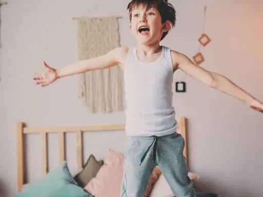 Bambino iperattivo 4 anni cosa fare? Un bimbo salta sul letto, pieno di energia.