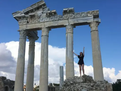 Radosna turystka pozuje na tle antycznych ruin w Side, Turcja.