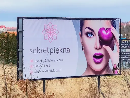 Reklama salonu "Sekret Piękna" z wizerunkiem kobiety i sercem. Personalizacja reklam pozwala dotrzeć do klientów z ofertą dopasowaną do ich potrzeb.
