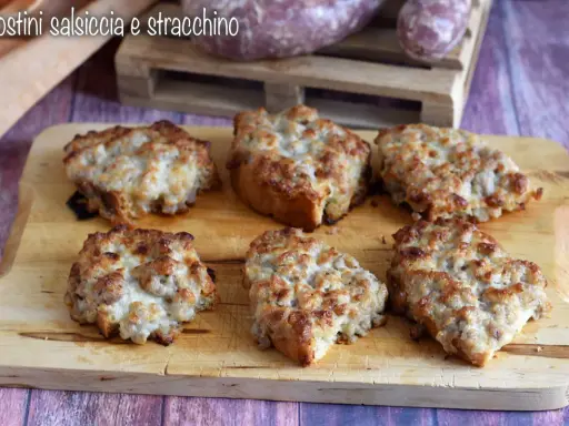 Sei crostini salsiccia e stracchino dorati e filanti, pronti per essere gustati.