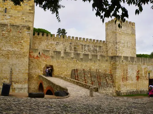 Das Castelo de São Jorge in Lissabon mit seiner steinernen Brücke und den Zinnen.