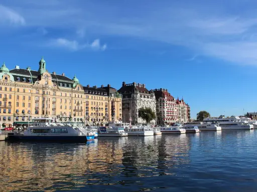 Vackra byggnader längs vattnet i Östermalm, Stockholm, med flera båtar förtöjda.