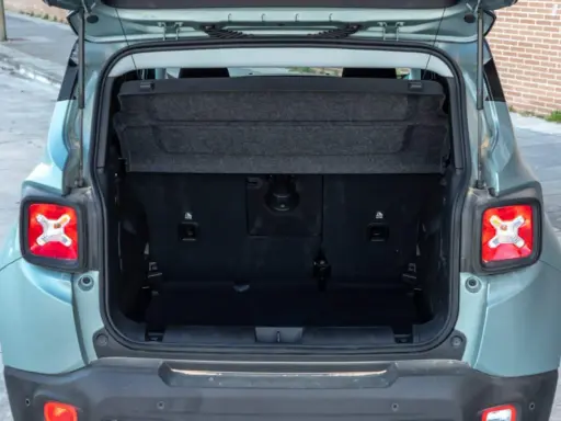 Maletero abierto de un Jeep Renegade color verde menta, mostrando el espacio de carga y la tapa retráctil.