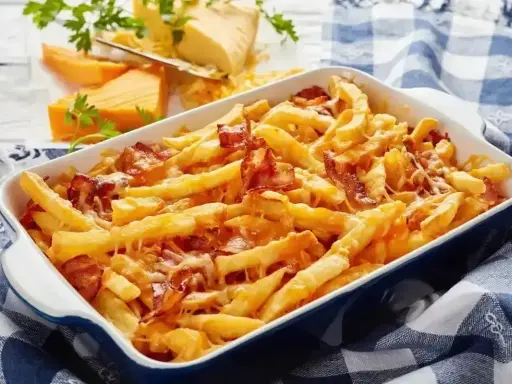 Zapiekane frytki z serem i chrupiącym boczkiem, podane w niebieskiej brytfance na kratkowanym obrusie.
