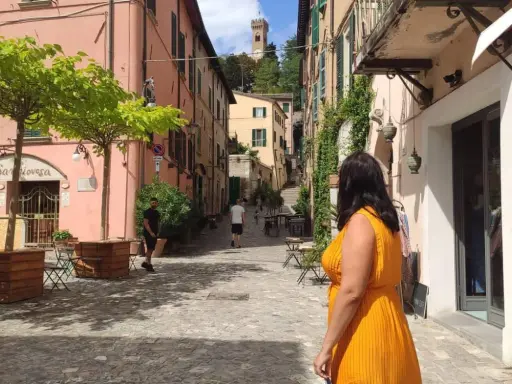 Un vicolo pittoresco con un campanile in lontananza, perfetto per scoprire cosa vedere vicino Rimini.