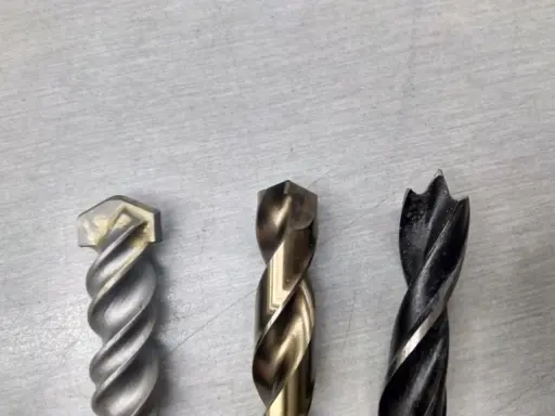 Tres brocas diferentes: una para mampostería, una para metal y una para madera. Cada broca tiene un diseño único para su propósito.