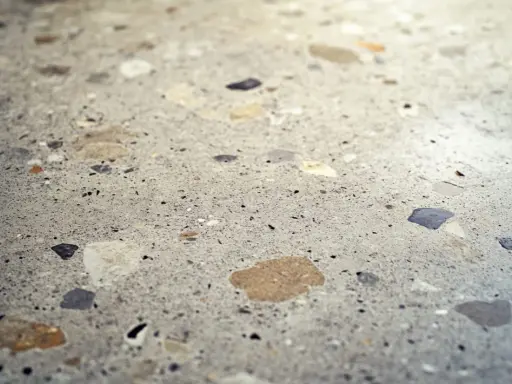 Superficie de terrazo con fragmentos de piedra de diversos colores, lista para pulir y revelar su brillo natural.