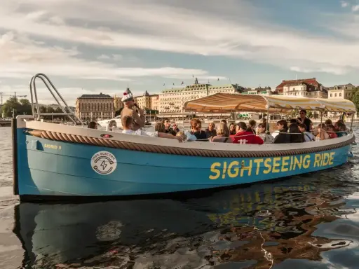 En blå båt med texten "SIGHTSEEING RIDE" tar passagerare på en tur i Stockholm.